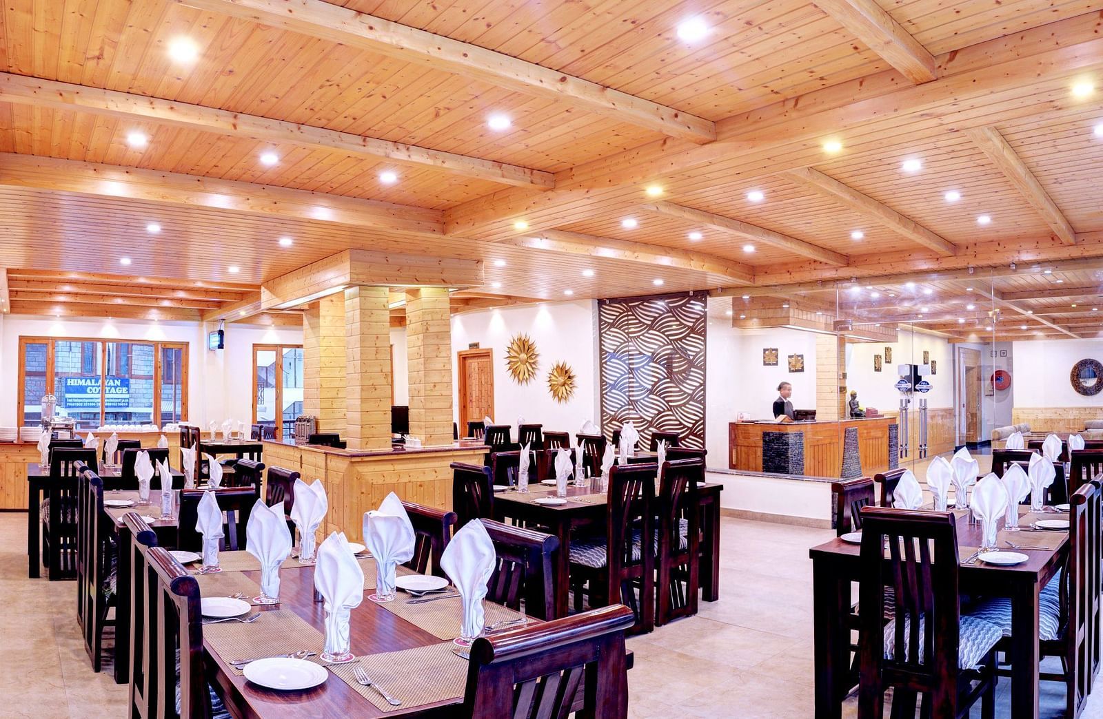 Image of a restaurant with tables and chairs and wooden ceiling at Summit Chandertal Regency Hotel & Spa