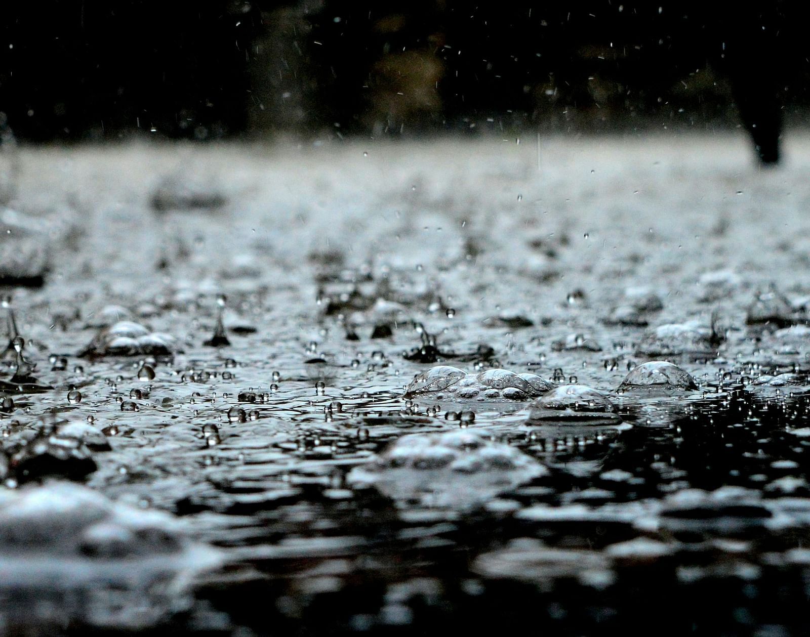 A ground-level view of a surface covered in water, with dark blurred background. 