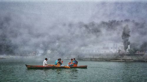 three people on a boat ride under a cloudy sky
