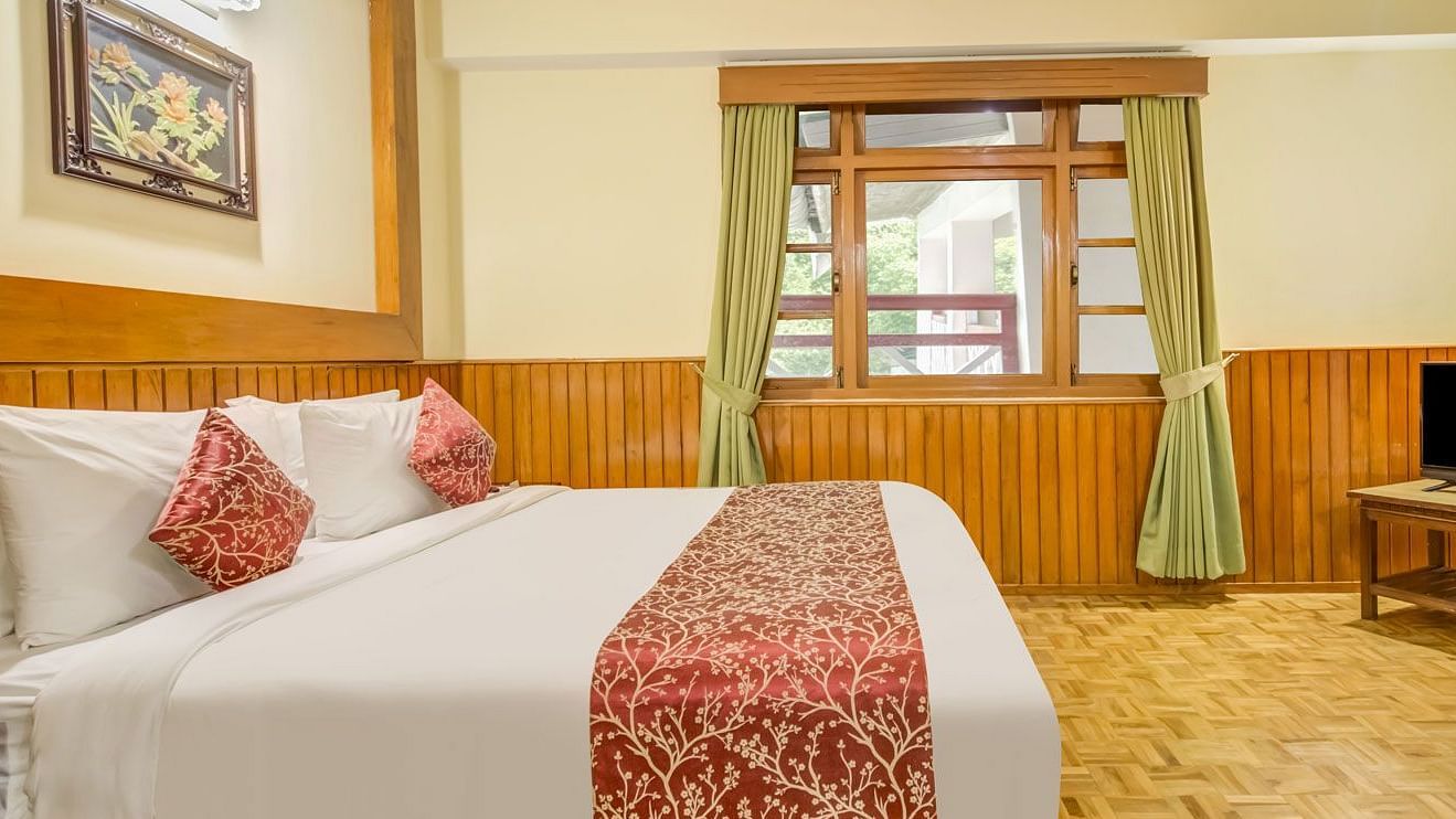 Side view of a room with bed and a television in front at Summit Tashi Ghang Heritage Resort, Pelling
