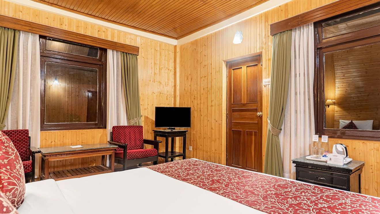 Image of a room with bed and windows on two sides on the room at at Summit Tashi Ghang Heritage Resort, Pelling