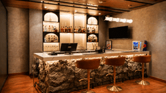 Bar counter at Pride Premier Pune with high stools, display shelves and warm ambient lighting.