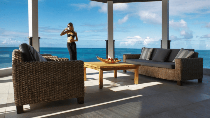 a modern living space with large windows overlooking a body of water.
