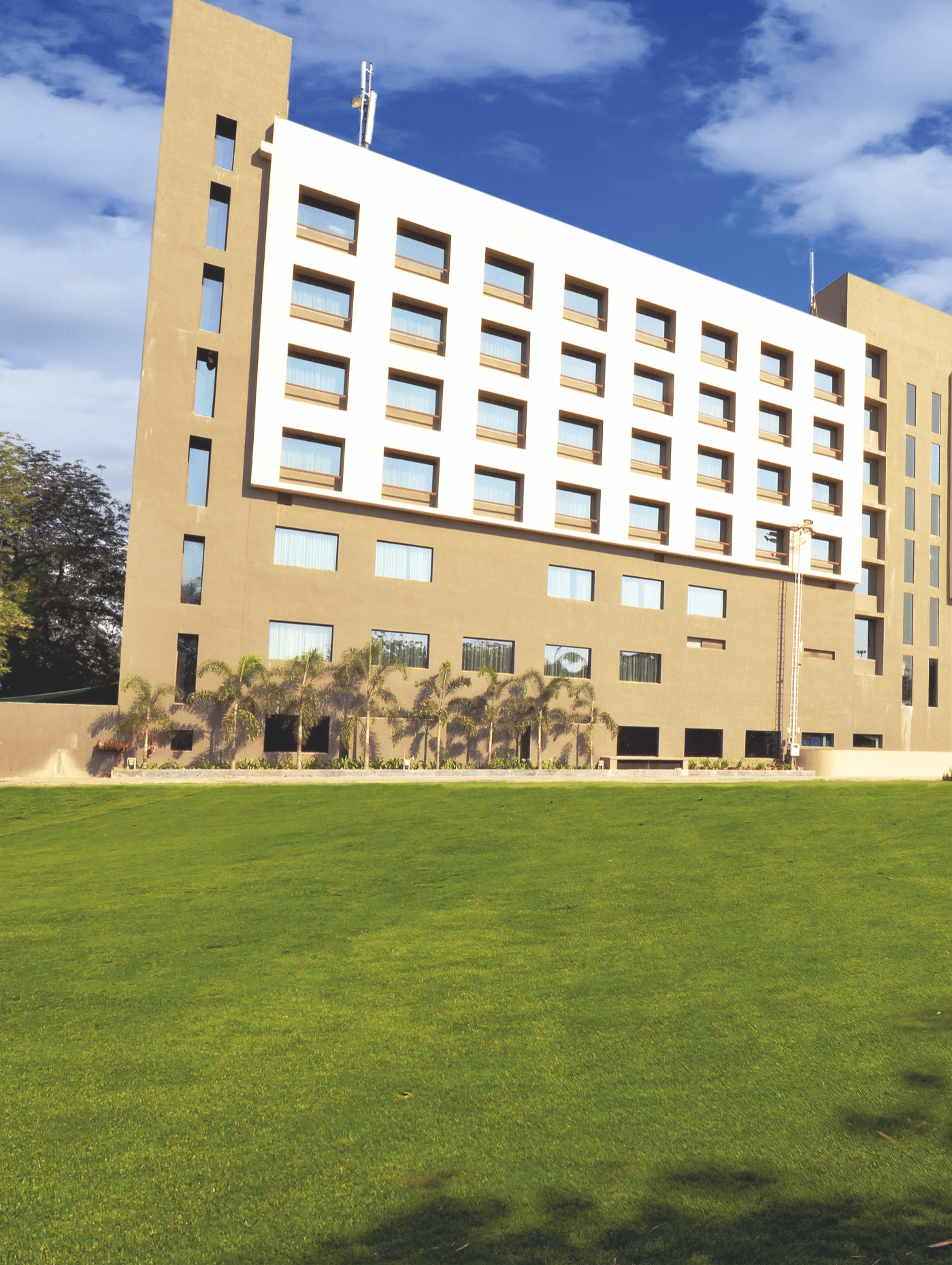 Exterior view of hotel building with expansive lawn – Narayani Heights Hotel & Resorts