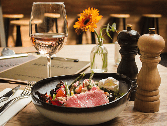 a wine glass kept beside a bowl of food