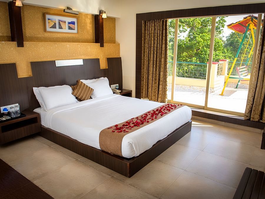 Adamo Resort Matheran - A view of the bed beside the window in Royal suite bedroom