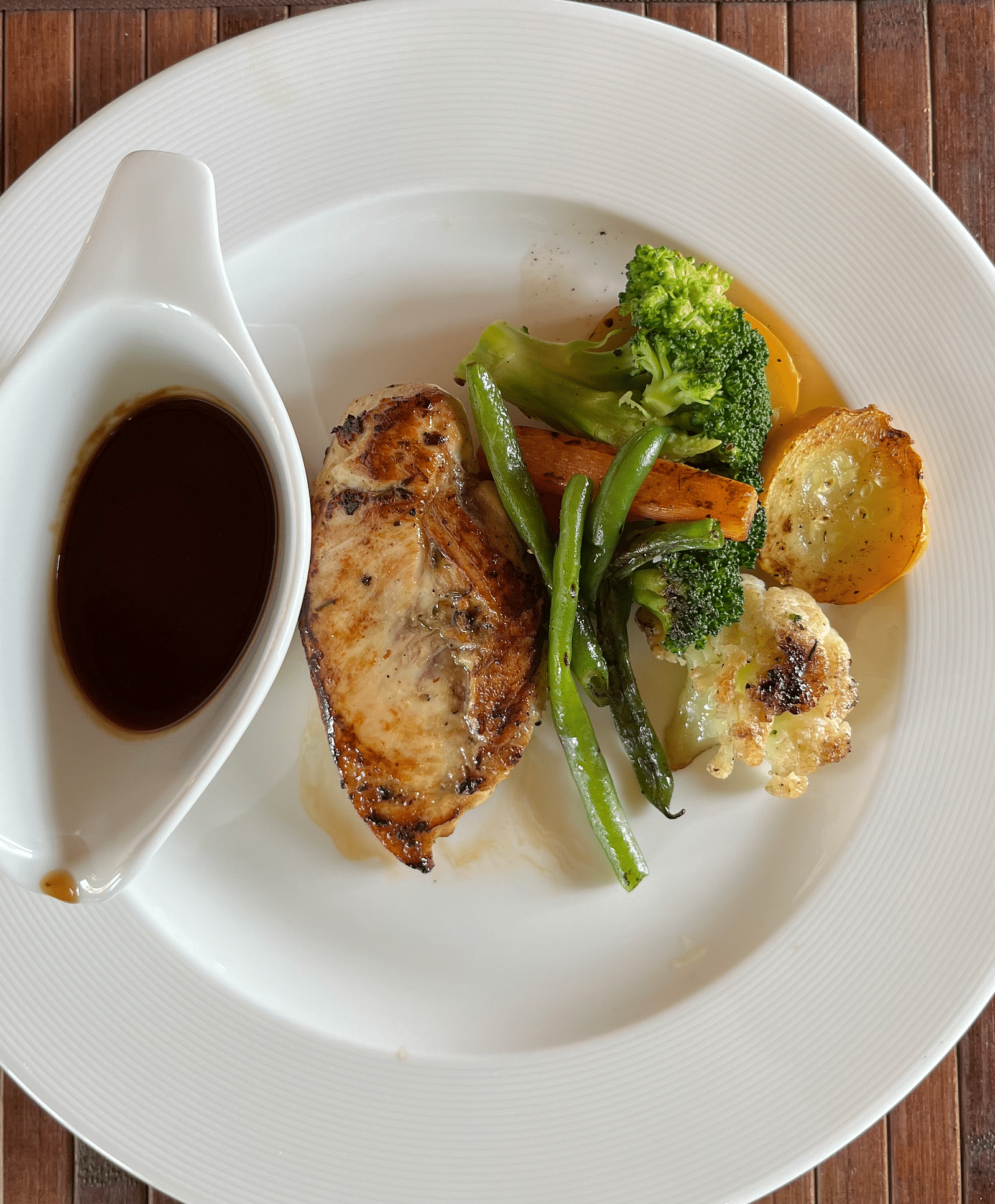 An image of food placed on a white plate with sauce by the side - Aalia Jungle Resort & Spa