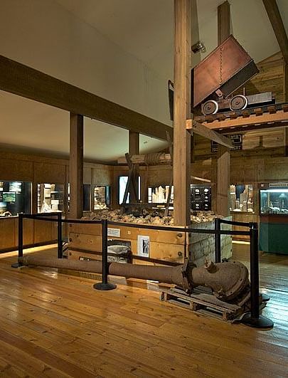 Interiors of a museum with wooden theme and a construction equipment placed in the middle.