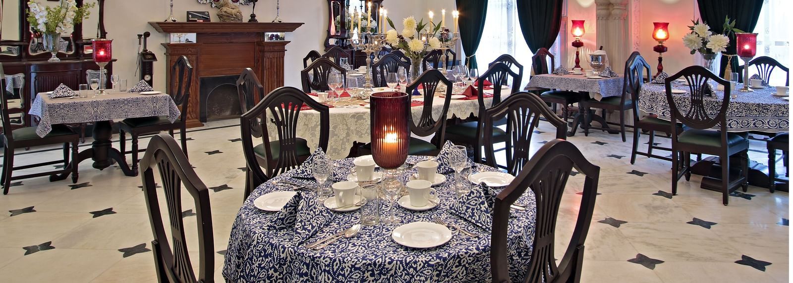 A lavish indoor dining area with classic interiors, chandeliers, and ornate furniture - Khas Bagh, Jaipur.
