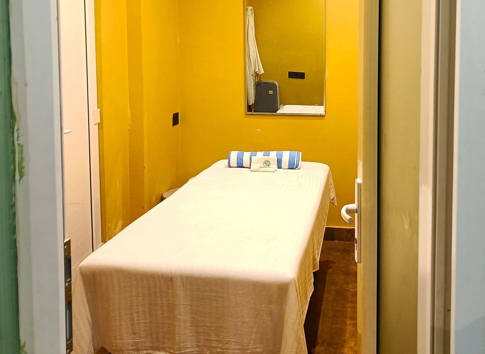 Spa room at DLS Forest Vines Resort as seen from the entrance, with a neatly made massage bed.