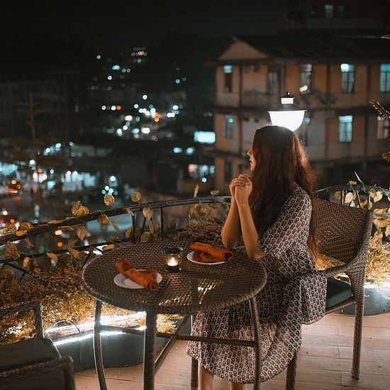 a girl sitting at the rooftop at Sky Grill