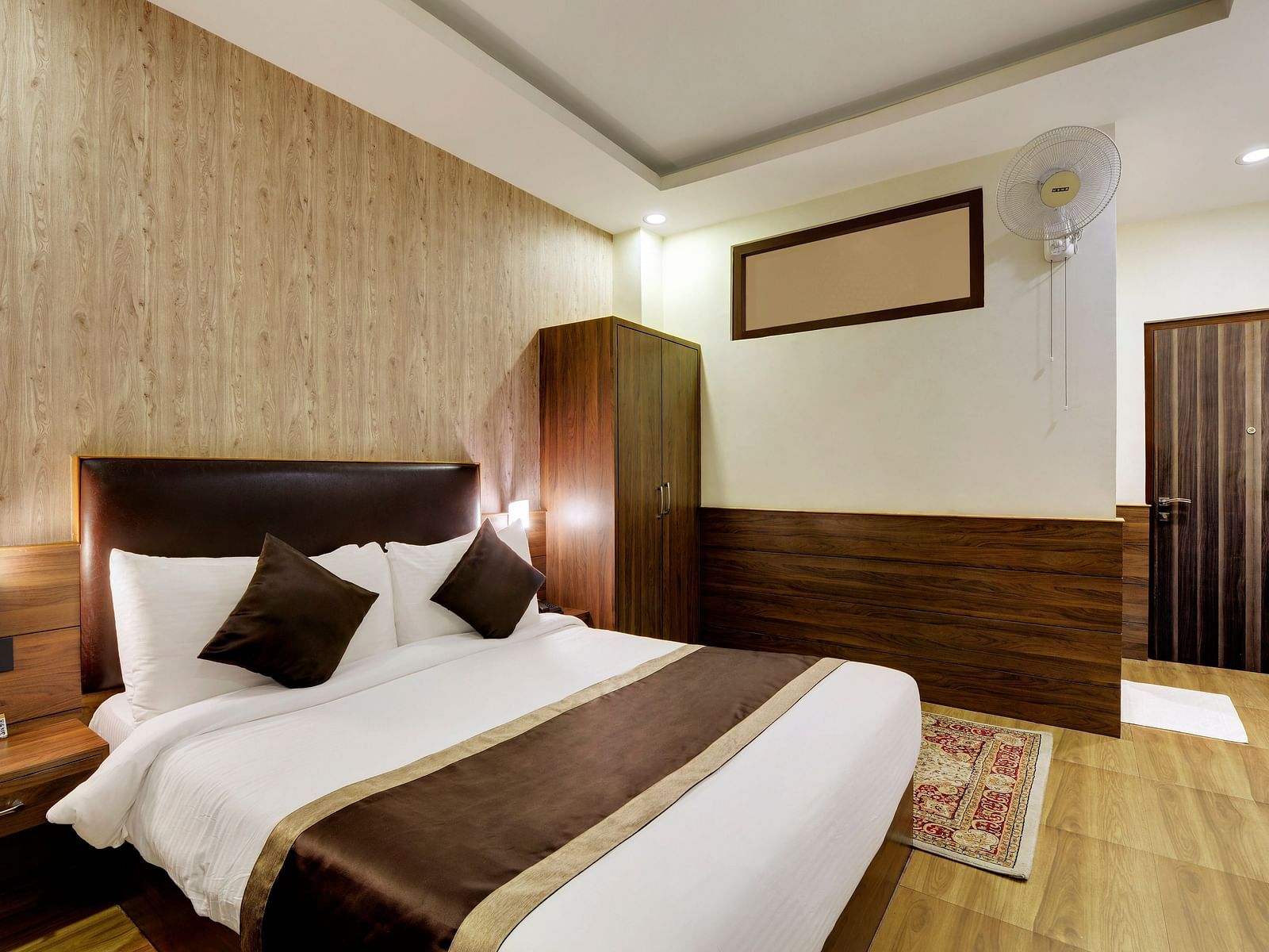 A queen bed with side tables and lamps on either side inside Deluxe Room - Sumitel Shangrila, Deorali