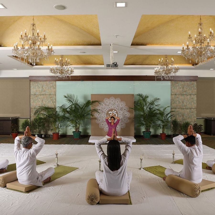 Heritage Village - image of people performing yoga movements led by a professional trainer