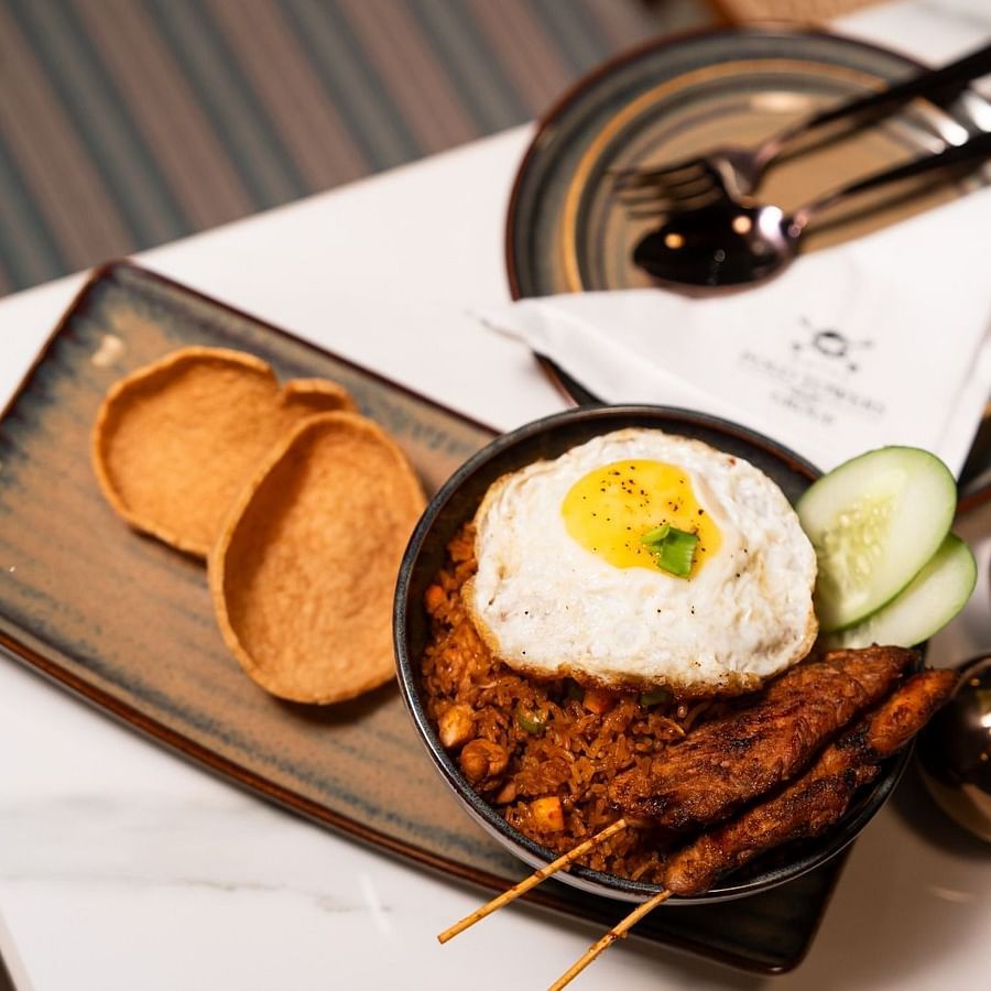 alt-text An image featuring a rectangular plate with chips, a rice bowl, and an additional plate on the side with cutlery and a tissue.