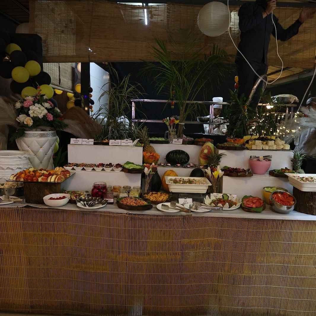 A lavish buffet spread presented on a long table with various dishes and decorative elements at Lords Inn Vadodara.