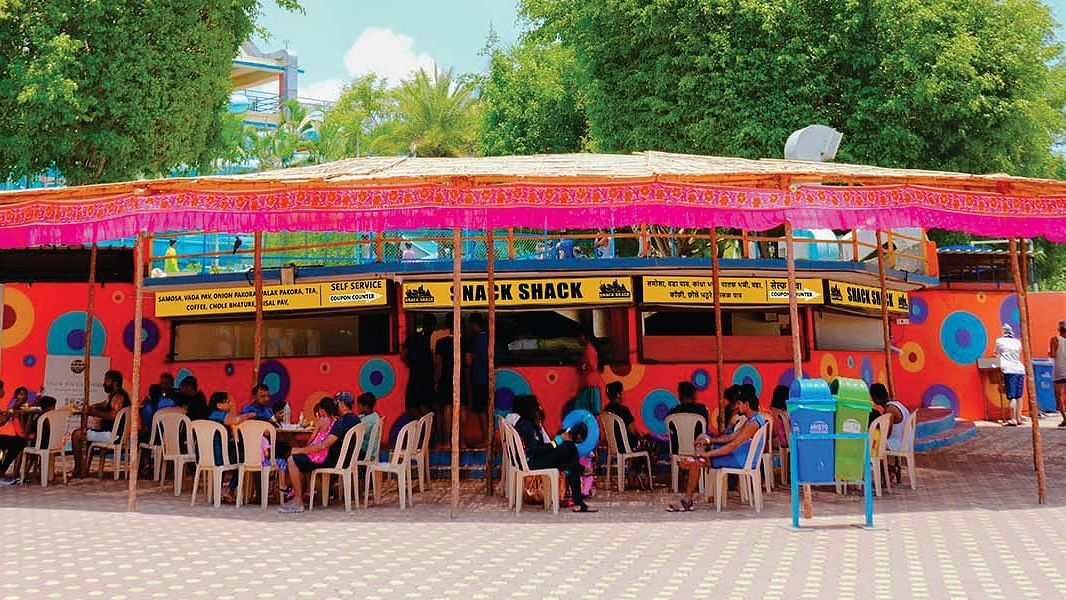 Street Food Eatery with Colorful Canopy and Seated Patrons in Urban Setting | Diamond Parks, Pune 
