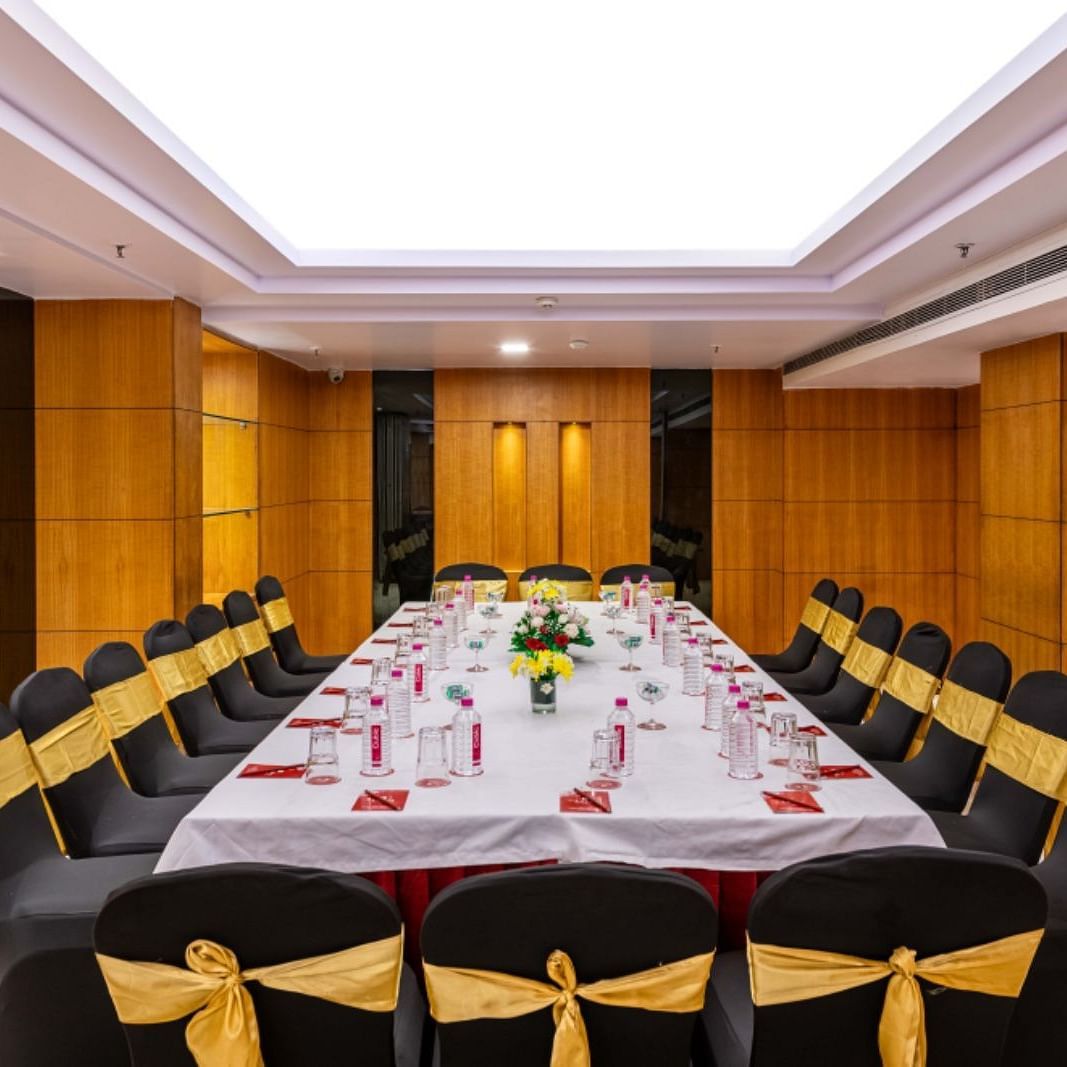 a boardroom meeting arrangement at a Banquet hall in Libra Lords Inn Jaipur with wood-panelled walls and ceiling lights