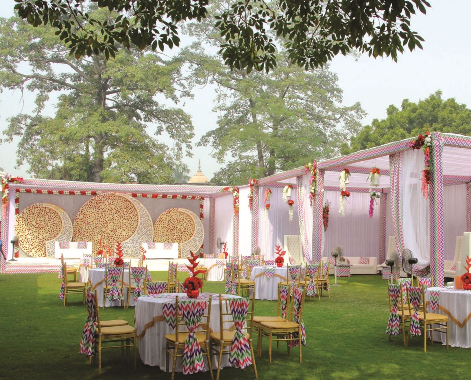 An outdoor banquet setup with round tables and floral decor at Gemini Continental, a hotel near lucknow railway station