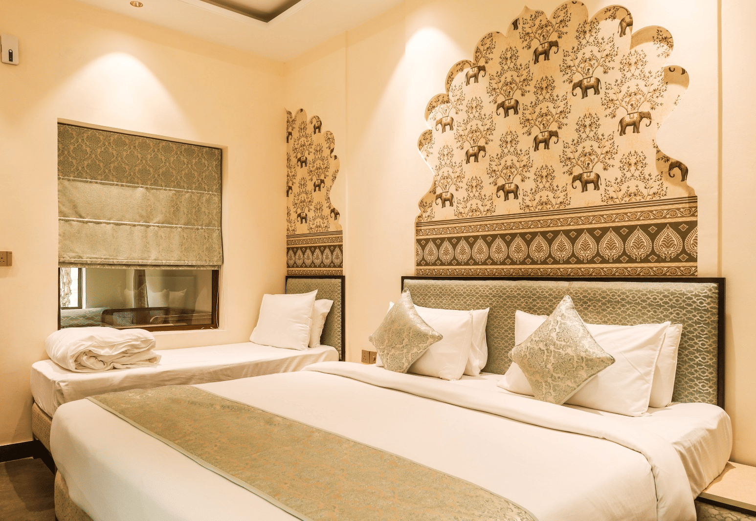 Bedroom with double bed, headboard design, and side tables at Beelwa Palace, Jaipur