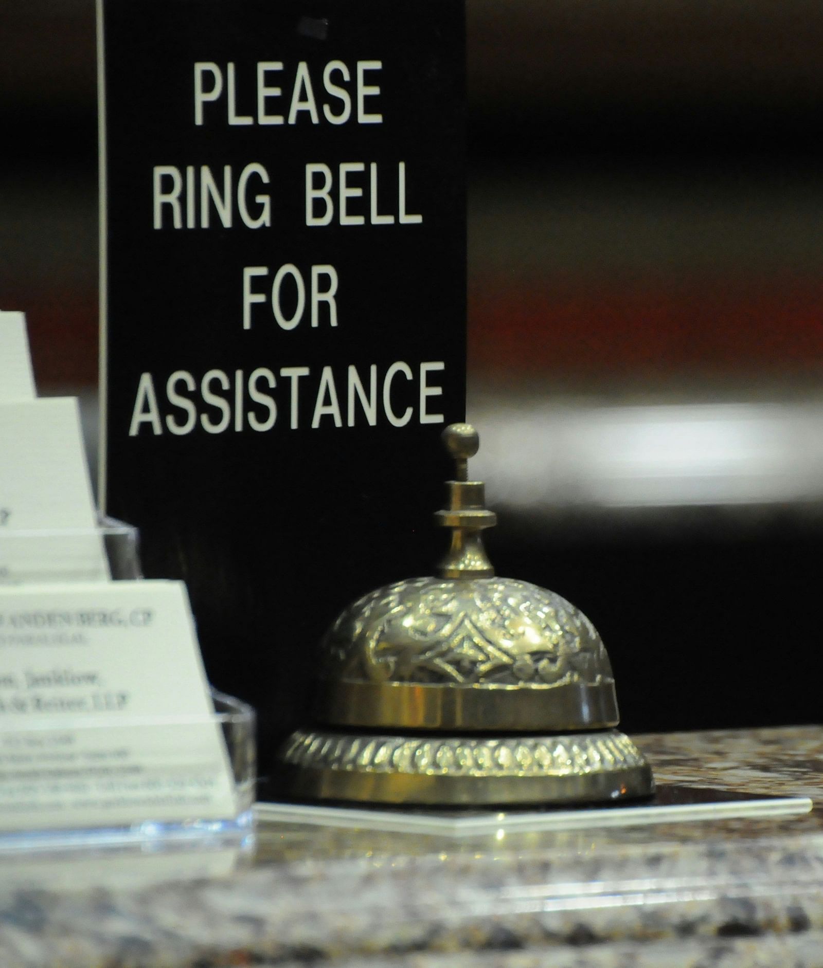 Reception bell with a sign reading Please ring bell for assistance.