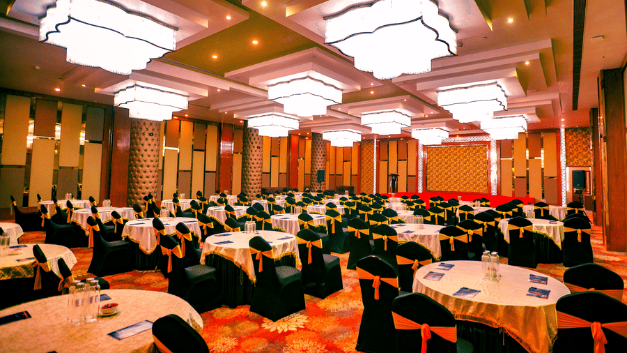 Full view of the elegant Mrighashira banquet hall, featuring a carpeted flooring with round tables surrounded by chairs at Leroy Grand, Yeshwanthpur.