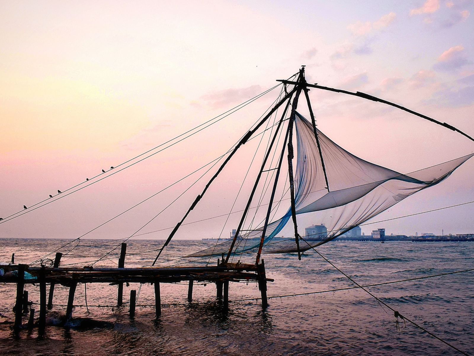 Beach view with a fishing net placed on a wooden bench.