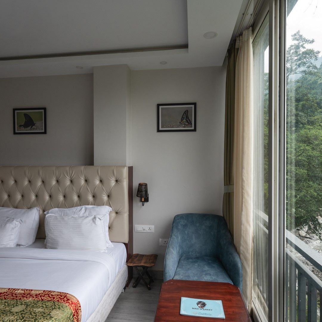 Spacious room with a king bed, chair and window with valley views.