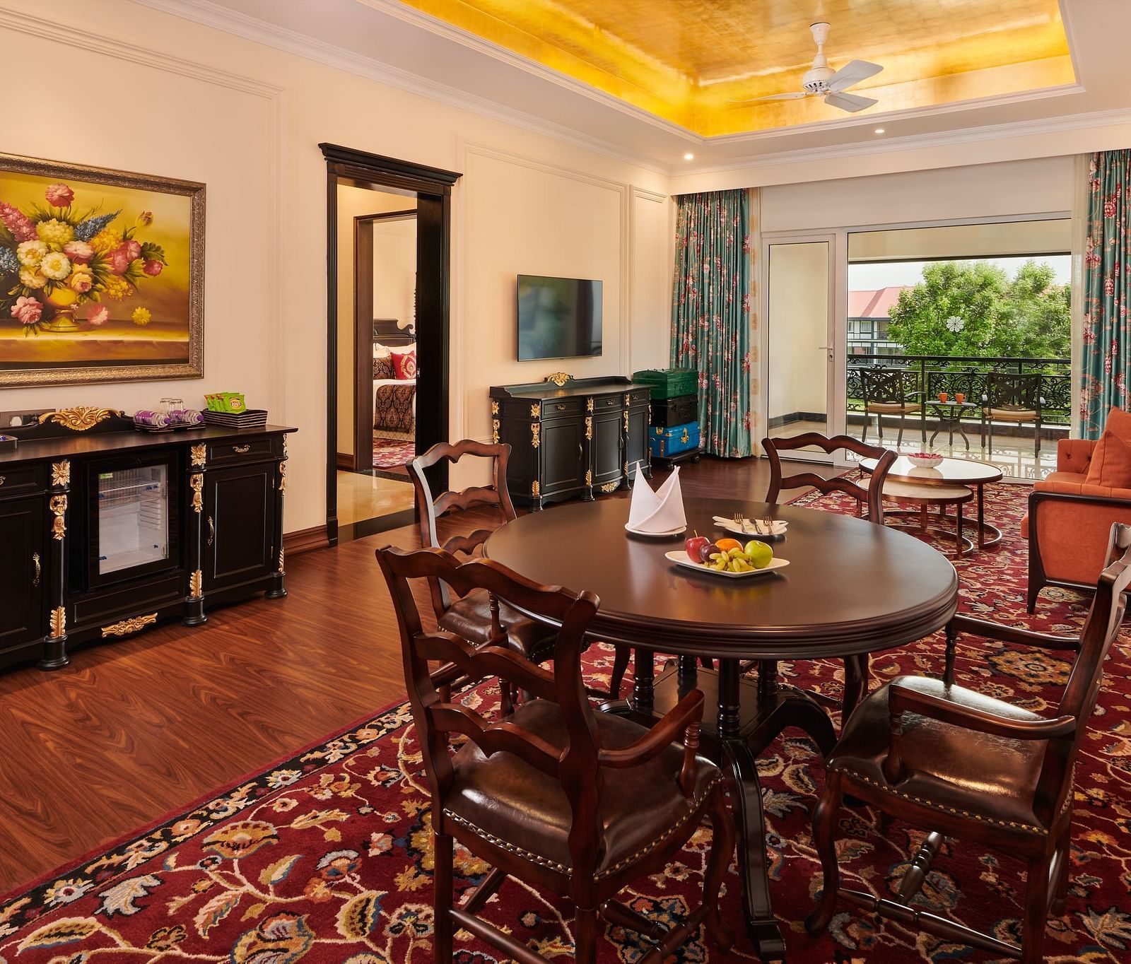 Dining area with round wooden table, classic furnishings, and large windows.