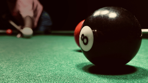 A close up view of the 8 ball with the player in the background 