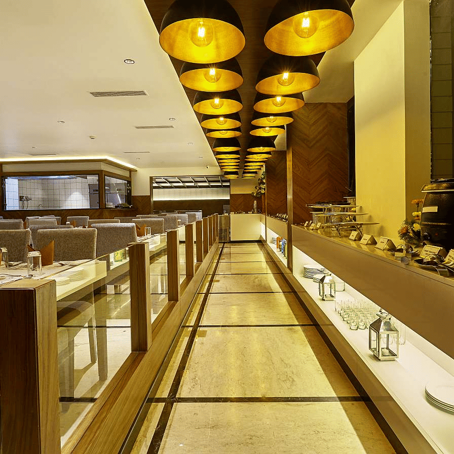 Elegant dining area with warm lighting, upholstered chairs, and decorative gold fixtures - The Citrine