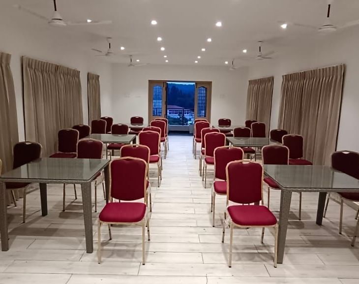Front view of Green Park hall viewed from a higher angle at WOW Naturefull Resorts with beige curtains covering the windows on both sides of the room.