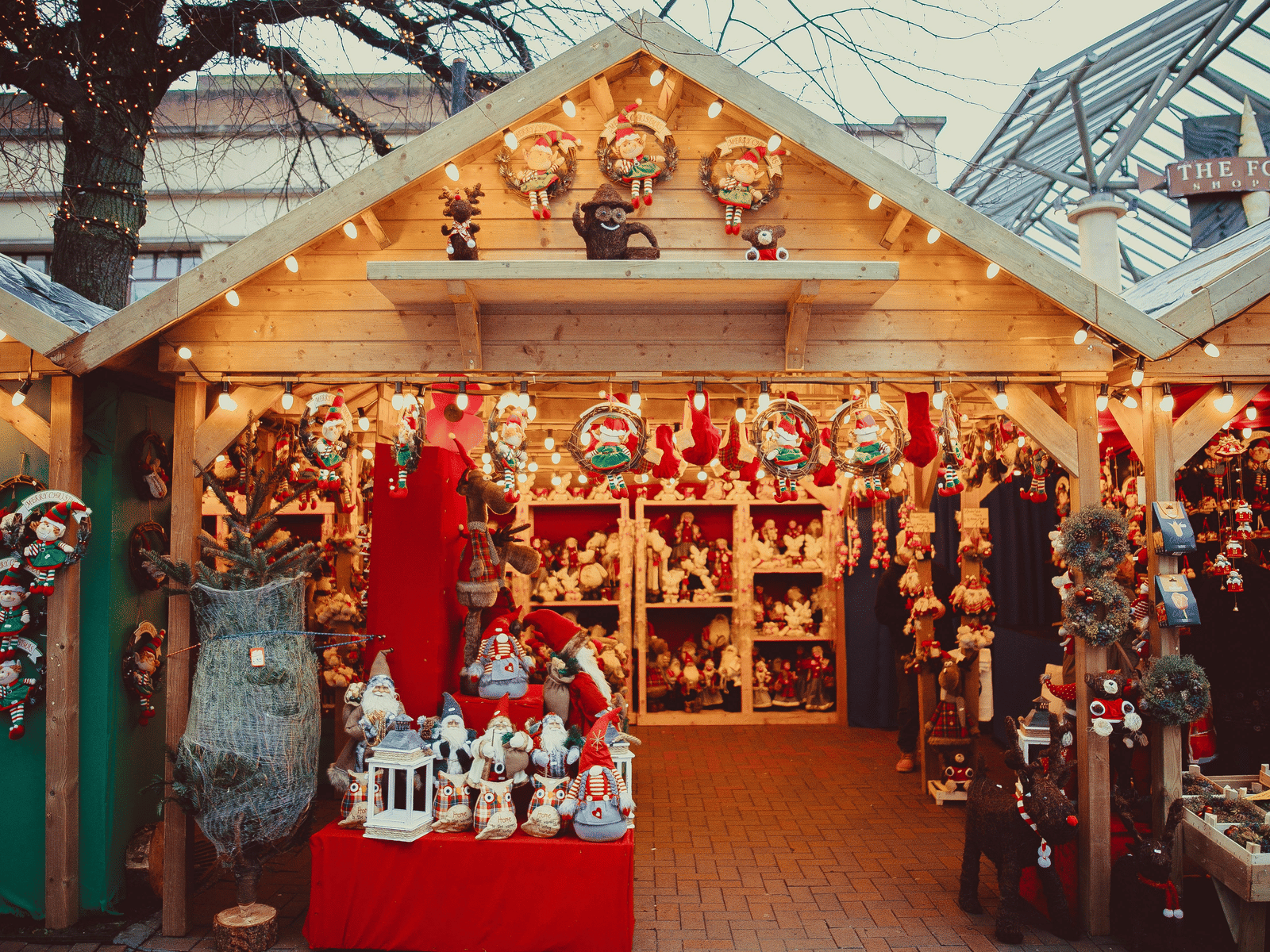 Festive holiday market stall decorated with Christmas ornaments and lights.