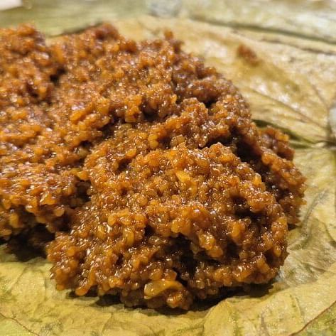 A traditional Indian sweet made of jaggery and rice, served on fresh green leaves for an authentic, earthy presentation.