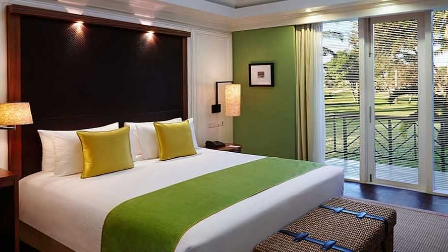 A double bed with side tables and lamps inside one of the rooms - Caravela Beach Resort, Goa