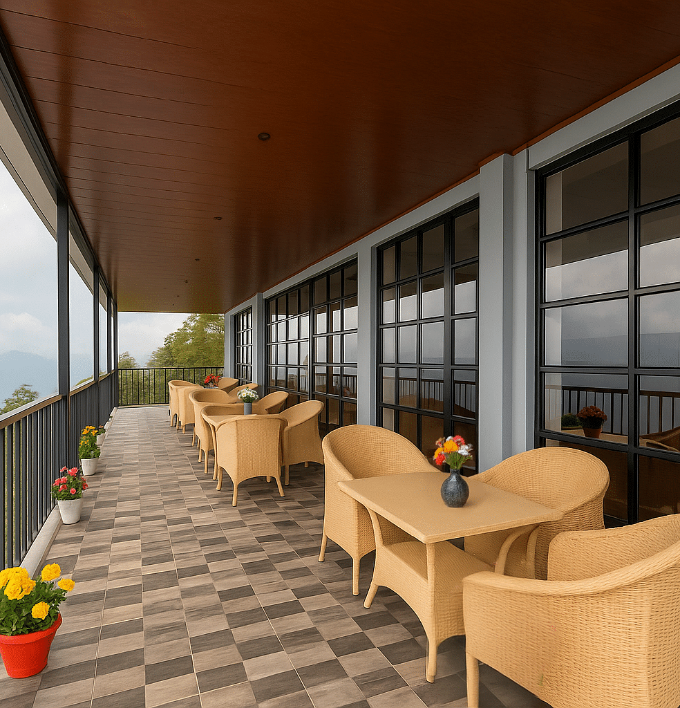 A scenic outdoor dining terrace at Summit Enigma Resort & Spa overlooks a mountainous landscape, featuring several tables with wicker chairs and potted flowers.