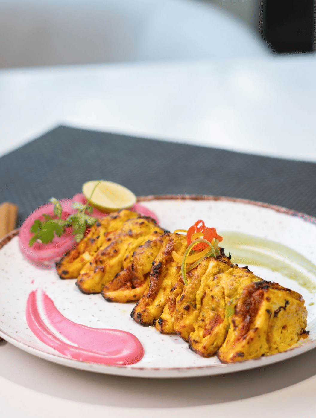 A plate of golden-brown appetisers with a sauce and garnish, stating Happiness served on a plate! at Cenneys Gateway.