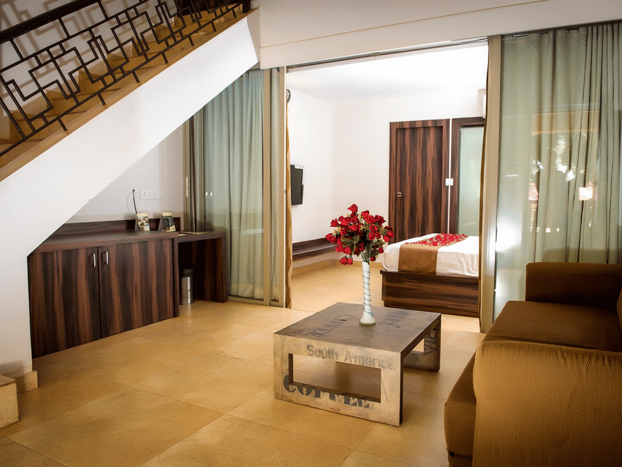 Deluxe villa bedroom living  room interior featuring a sofa and coffee table - Adamo Resort Matheran.