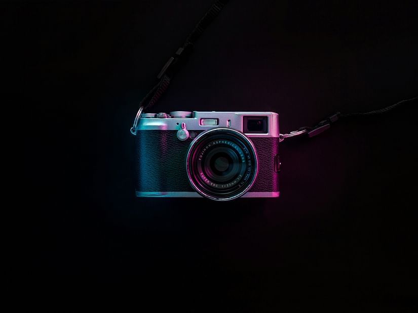 A single DSLR camera as seen from above with a black background.