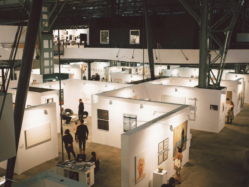 A top view of a trade show with people walking around different stalls.