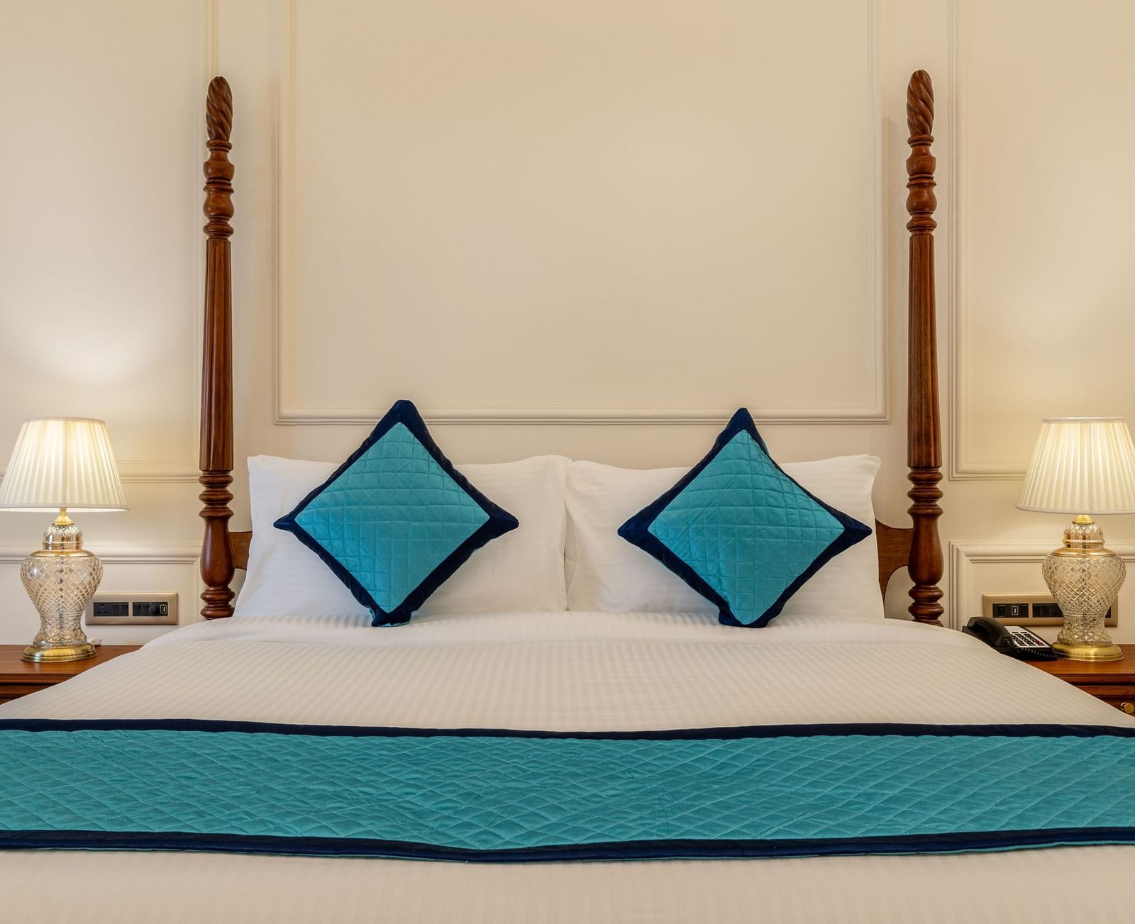 close up image of a double bed with two blue cushions kept over it - Brij Castle, Jaipur