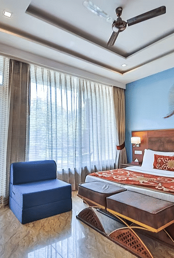 Image of Premium Room with bed and televsion at Summit By The Ganges Beach Resort & Spa, Rishikesh