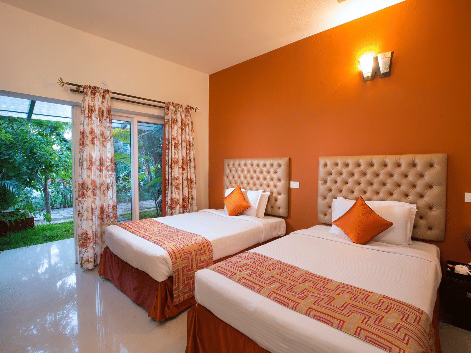 This photo and the ones below are cloned-NA. Another look at an inviting hotel room at Kairos, Yelagiri, with a white tufted headboard, orange accents, floral curtains and a view  - Kairos, Yelagiri
