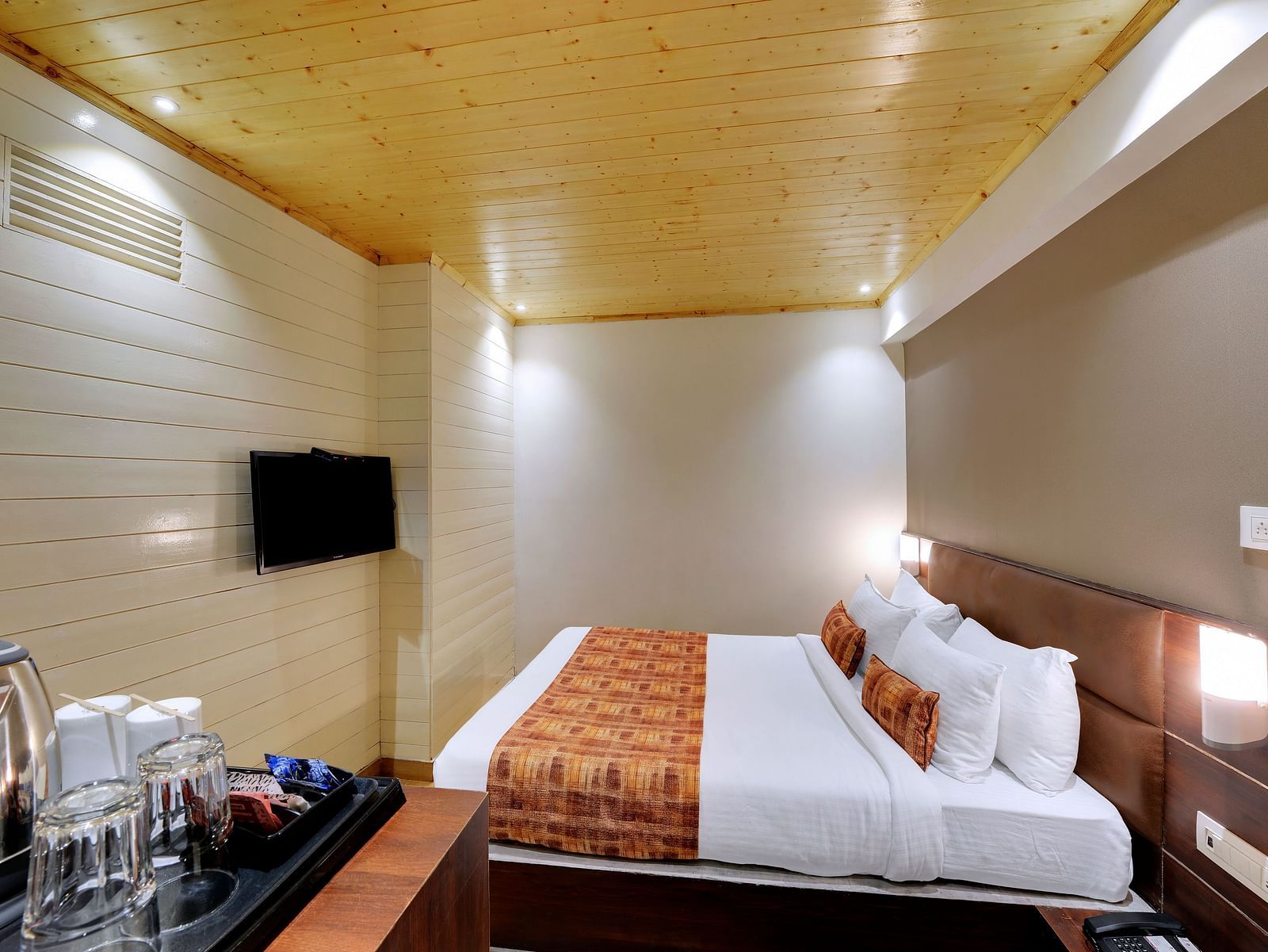 An image of a room with a queen size bed, TV and room amenities like tea coffee maker - Sumitel Vista TV Tower