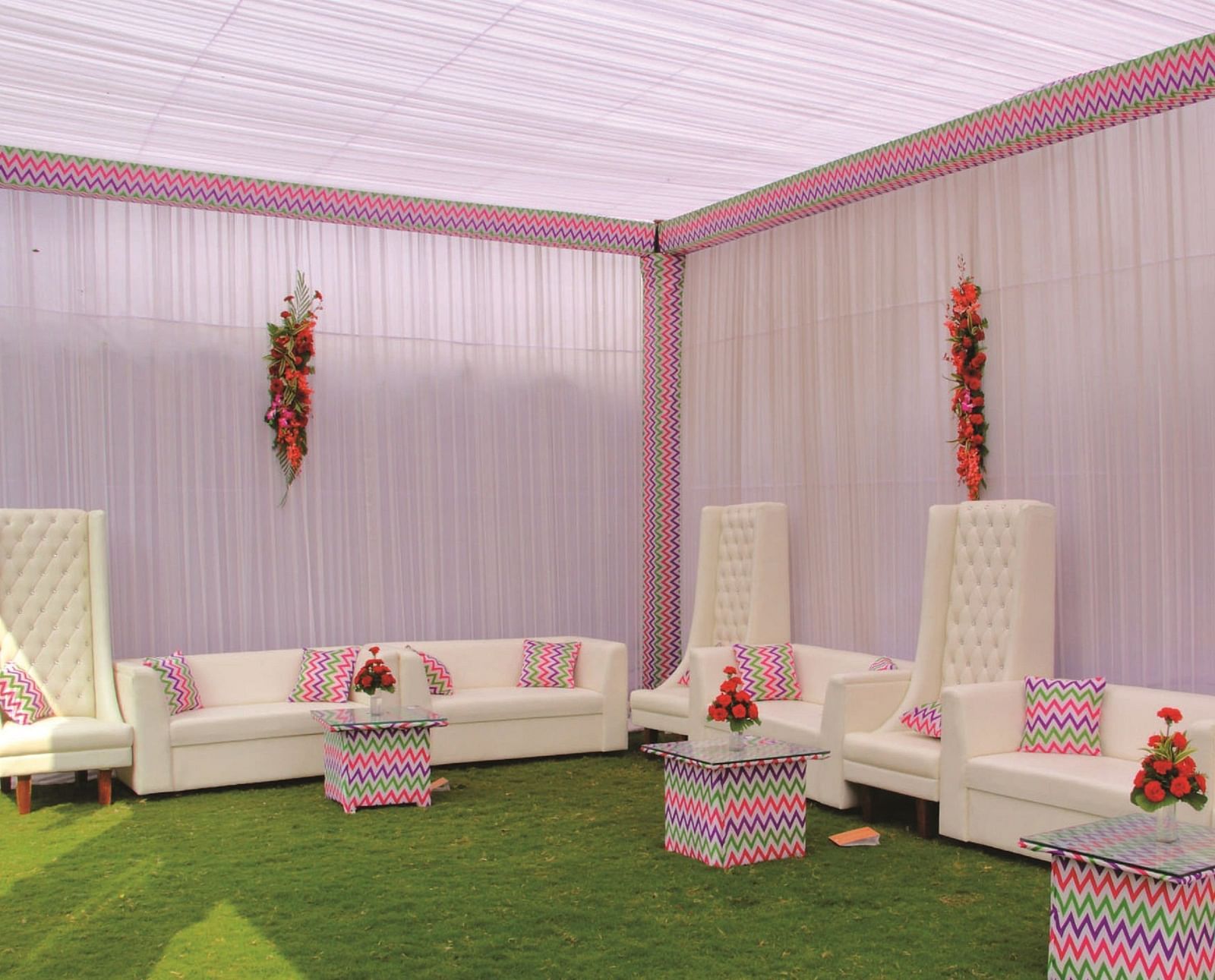 Side-angle view of a seating area with white sofas and pink canopy for an event | Gemini Continental