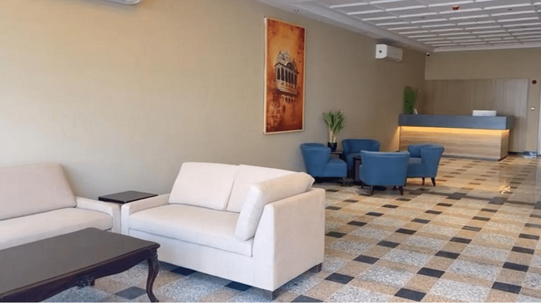 A spacious reception area at Urban Suites by BluSalzz, Jaipur, featuring cushioned sofas, tables, and warm lighting for a welcoming ambience.