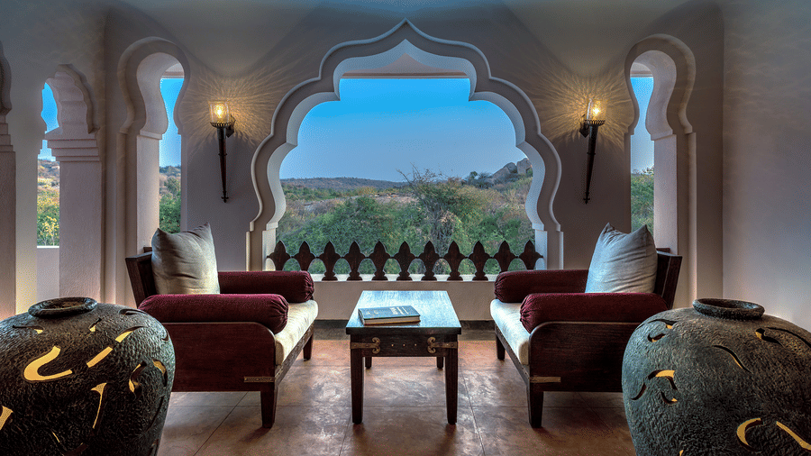 Royal suite living area with arched windows and traditional décor at Evolve Back Hampi