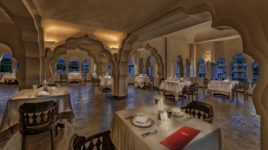 Ornate arched heritage restaurant interior at Evolve Back Hampi