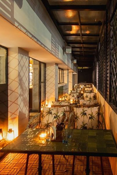 A warmly lit outdoor dining area with multiple tables and chairs at the Polo Hotel Shillong.