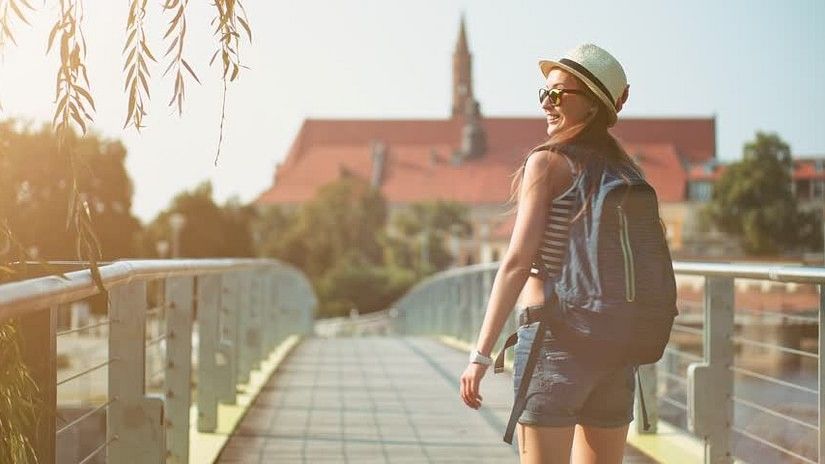 Female traveller walking in a tourist destination with the sun shining on her