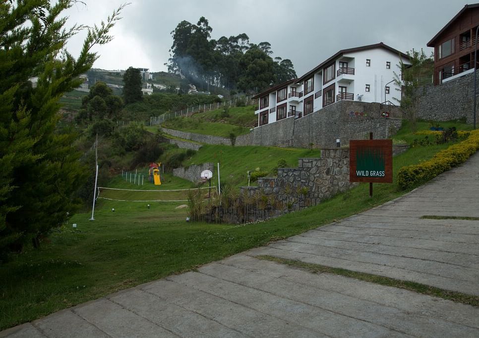 Exterior view of the property with a trail leading to the hotel surrounded by lush greenery - GReaT Trails Kodaikanal By GRT Hotels